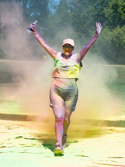 Women crossing finish line covered in paint